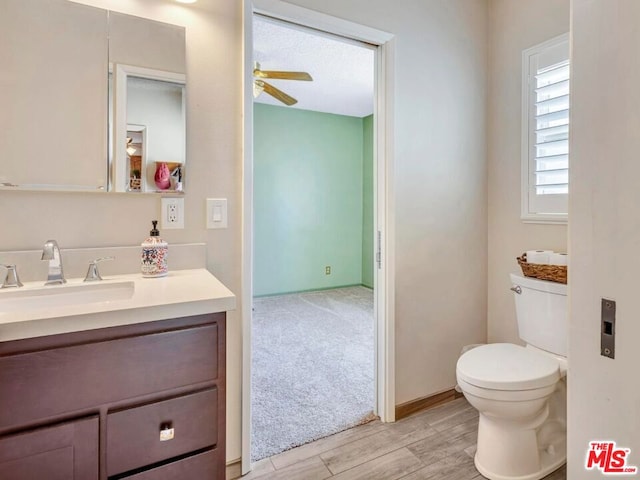 bathroom with ceiling fan, hardwood / wood-style floors, toilet, and vanity