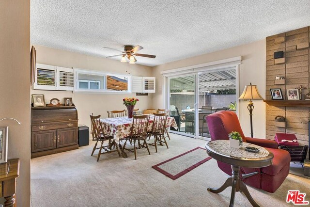 carpeted dining area featuring a textured ceiling and ceiling fan