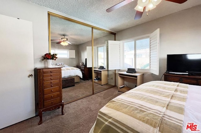 carpeted bedroom featuring ceiling fan, a textured ceiling, and a closet