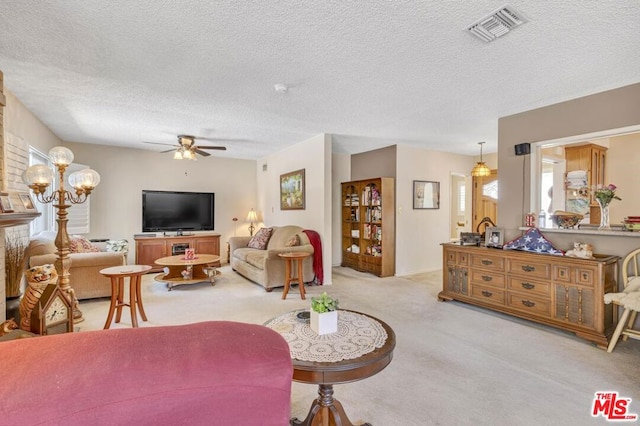 living room featuring ceiling fan, a textured ceiling, and light carpet