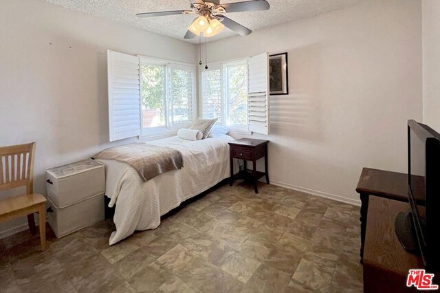 bedroom featuring ceiling fan and a textured ceiling