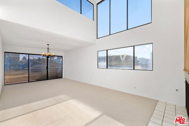 unfurnished living room featuring tile patterned flooring and a chandelier