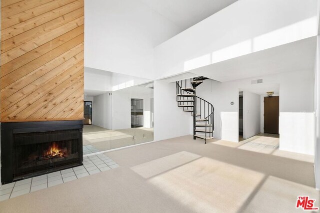 unfurnished living room with light carpet and a towering ceiling