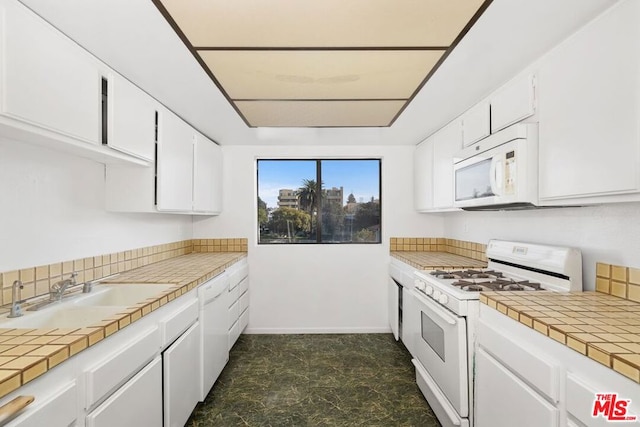 kitchen featuring white cabinetry, sink, tile countertops, and white appliances