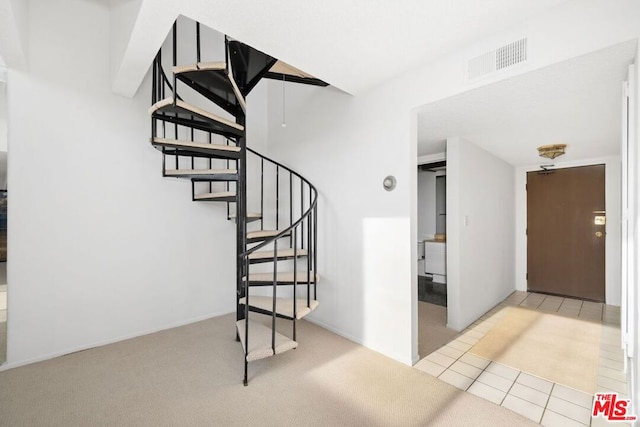 stairway with tile patterned floors