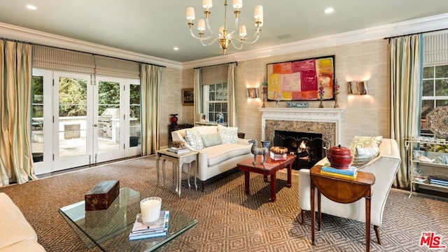 carpeted living room featuring french doors, a high end fireplace, ornamental molding, and a notable chandelier