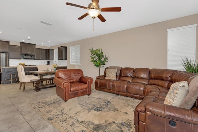 living room with ceiling fan and light tile patterned flooring