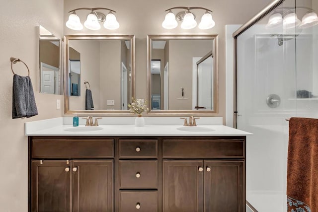 bathroom with a shower with shower door and vanity