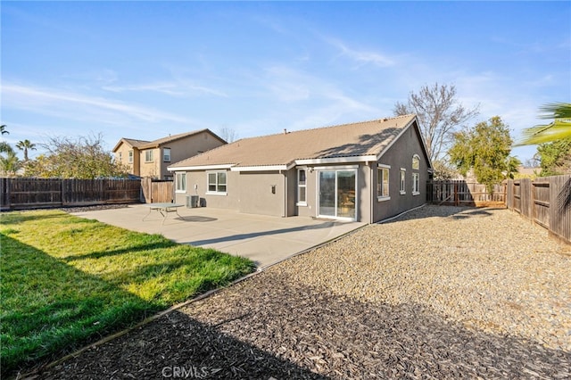 back of house featuring a lawn and a patio area