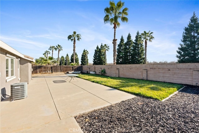 view of yard with central AC unit and a patio