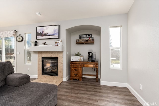 living room featuring dark hardwood / wood-style floors and a tile fireplace