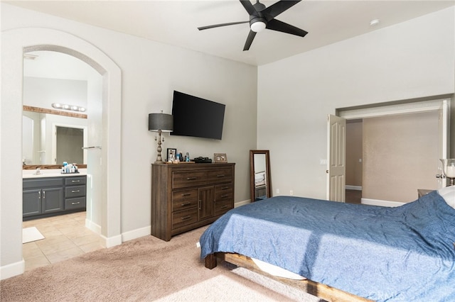 carpeted bedroom with ceiling fan, sink, and ensuite bath