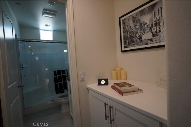 bathroom featuring a shower with shower door and toilet