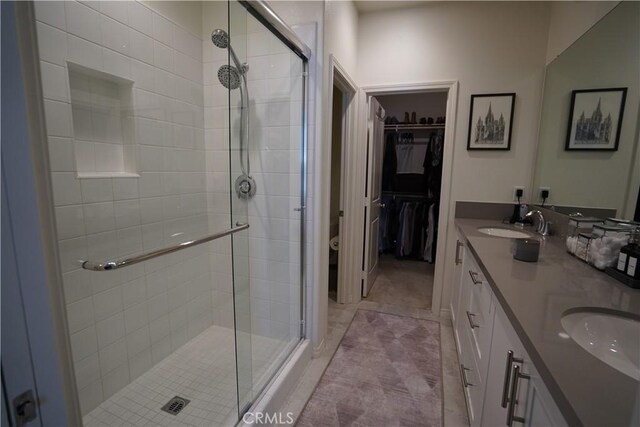 bathroom featuring walk in shower, vanity, and tile patterned floors