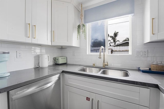 kitchen featuring stainless steel dishwasher, a wealth of natural light, sink, and white cabinetry