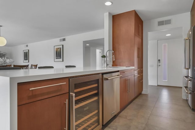 kitchen with wine cooler, sink, high quality fridge, and kitchen peninsula