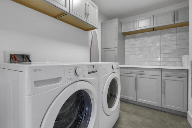 laundry area with washing machine and dryer and cabinets