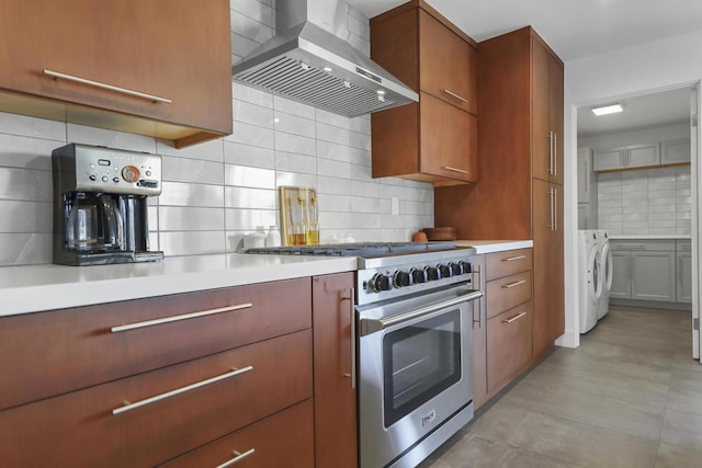 kitchen featuring tasteful backsplash, wall chimney range hood, and stainless steel stove