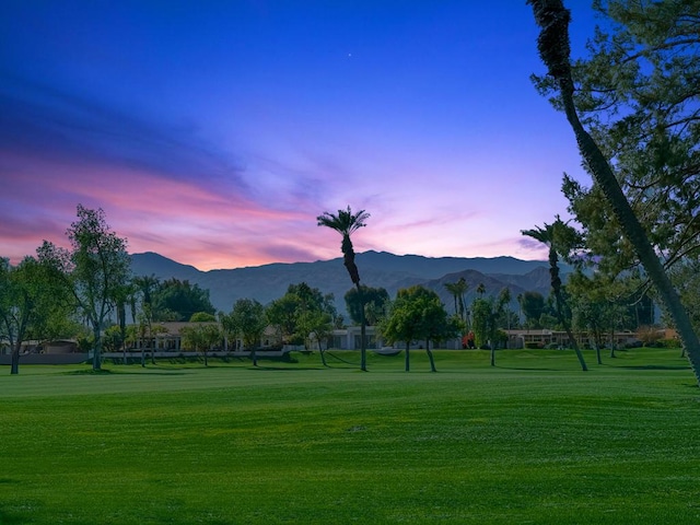 surrounding community with a mountain view and a yard