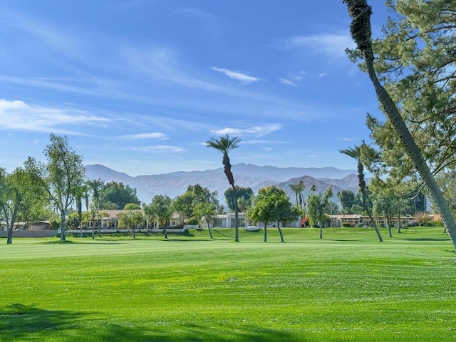 surrounding community with a mountain view and a lawn