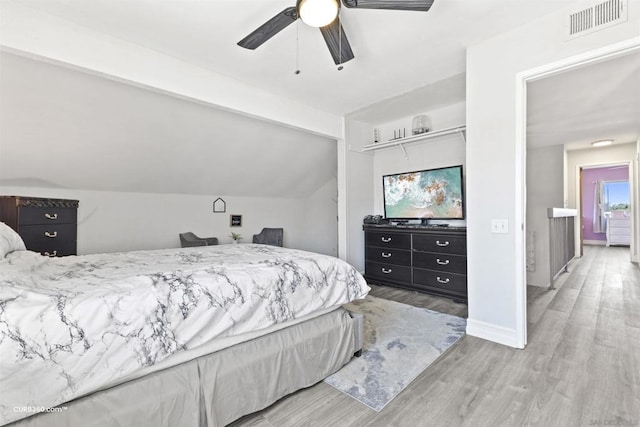 bedroom featuring ceiling fan, hardwood / wood-style flooring, and lofted ceiling