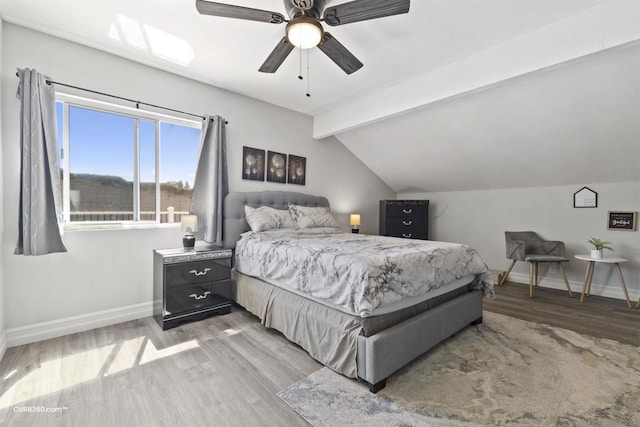 bedroom featuring ceiling fan, vaulted ceiling with beams, and wood-type flooring