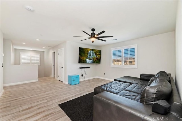 living room featuring ceiling fan and light hardwood / wood-style flooring