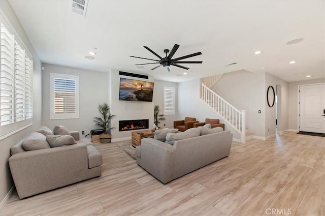 living room with ceiling fan and light hardwood / wood-style floors