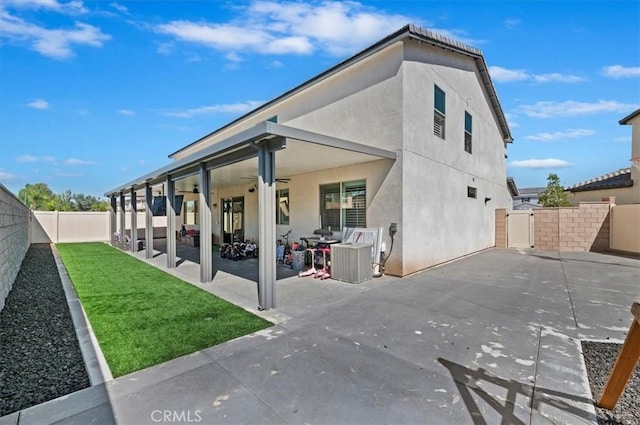 rear view of house with ceiling fan and a patio