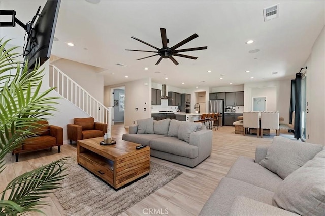 living room with ceiling fan and light wood-type flooring