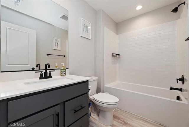 full bathroom featuring toilet, tiled shower / bath combo, wood-type flooring, and vanity