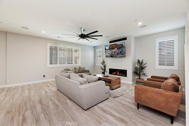 living room with ceiling fan and light wood-type flooring