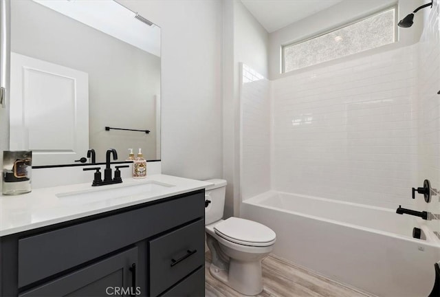 full bathroom featuring toilet, hardwood / wood-style flooring, vanity, and shower / bathing tub combination