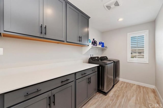 laundry room featuring washer and dryer and cabinets