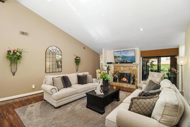 living room featuring hardwood / wood-style flooring, vaulted ceiling, and a fireplace