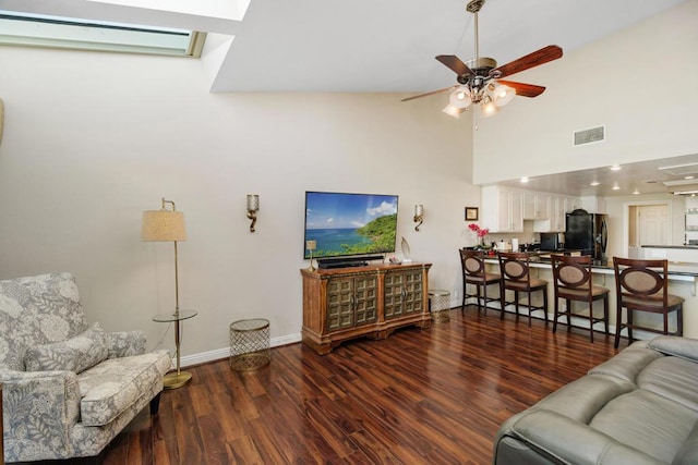 living room with ceiling fan, dark wood-type flooring, a towering ceiling, and a wall mounted air conditioner