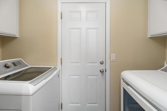 laundry area featuring cabinets and washer and clothes dryer