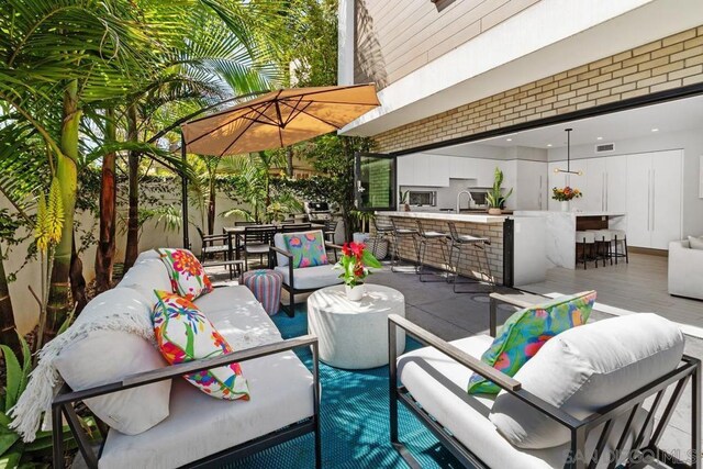 view of patio / terrace with a wet bar and an outdoor living space