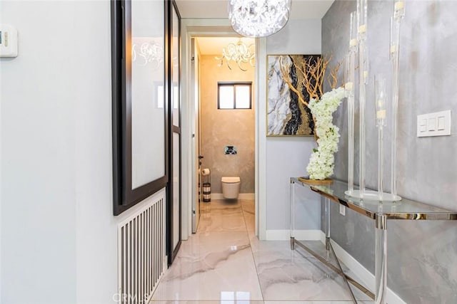 bathroom featuring toilet, radiator, and an inviting chandelier