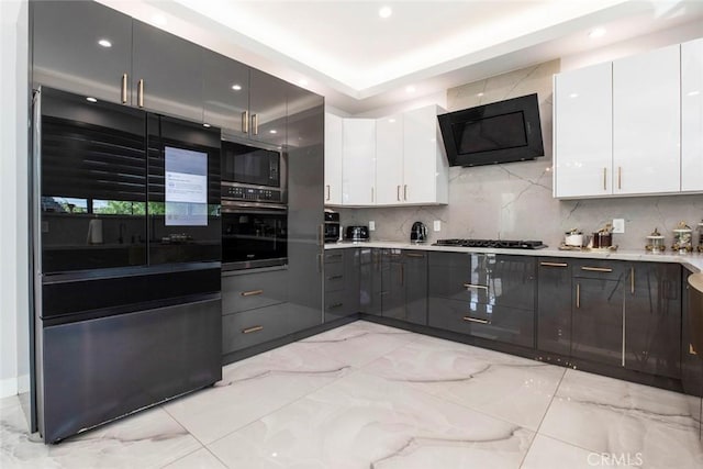 kitchen featuring stainless steel appliances, decorative backsplash, and white cabinets