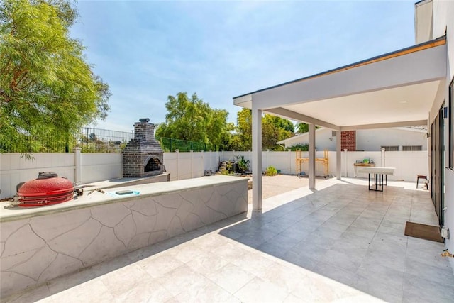 view of patio with an outdoor brick fireplace