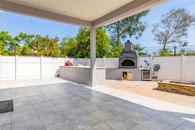 view of patio with an outdoor brick fireplace and an outdoor kitchen