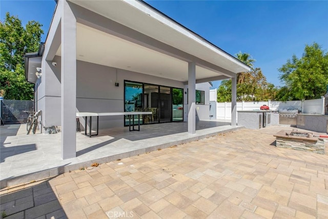 view of patio / terrace featuring an outdoor kitchen and a fire pit