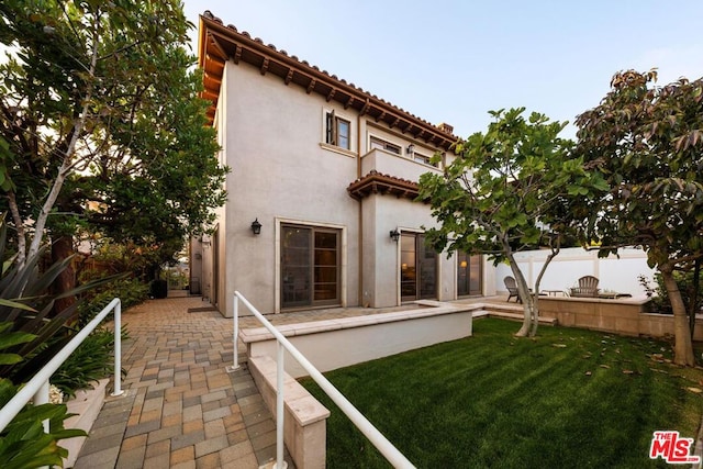 back of house with a balcony, a yard, and a patio