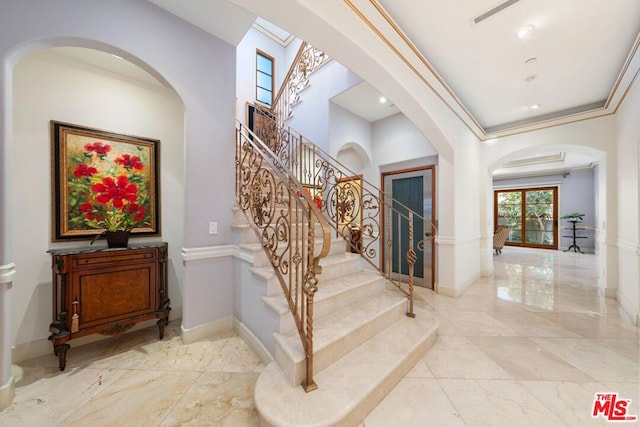 foyer entrance with crown molding and french doors