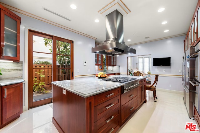 kitchen featuring tasteful backsplash, stainless steel gas stovetop, a center island, light stone countertops, and island range hood