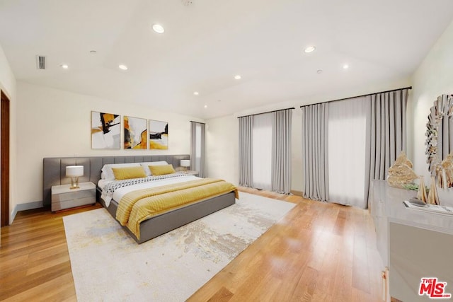 bedroom featuring light wood-type flooring and vaulted ceiling