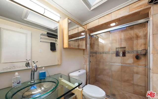 bathroom featuring toilet, ornamental molding, a shower with shower door, and vanity