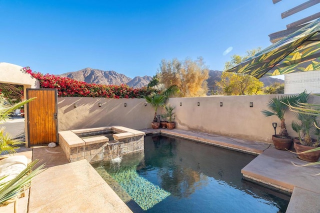 view of swimming pool with a mountain view, a hot tub, and pool water feature