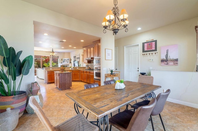 tiled dining area featuring ceiling fan with notable chandelier